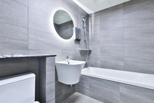 釜山的住宿－Shire Hotel Busan Station，浴室配有白色水槽和浴缸。