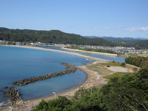 a beach with a bunch of rocks in the water at 一棟貸ゲストハウス　パンジー in Nachikatsuura