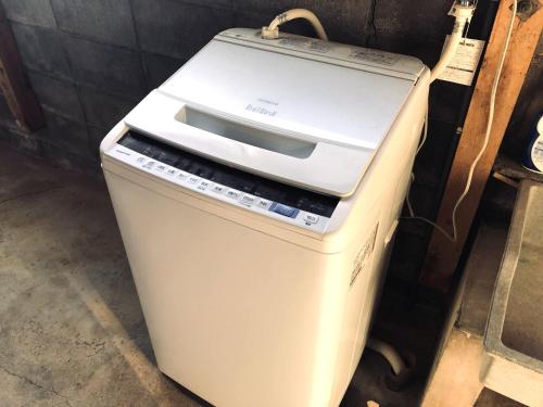 an old fax machine sitting next to a wall at 一棟貸ゲストハウス　パンジー in Nachikatsuura