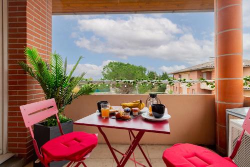 d'une table et de deux chaises sur un balcon avec petit-déjeuner dans l'établissement Studio ToulouseCityStay Basso Cambo, à Toulouse