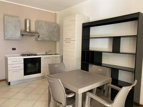 een keuken met een eettafel en stoelen bij La Lanterna - Appartamento con Giardino in Residence con Piscina in Desenzano del Garda