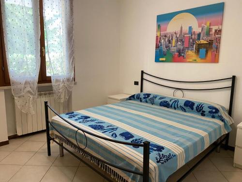 een bed in een slaapkamer met een schilderij aan de muur bij La Lanterna - Appartamento con Giardino in Residence con Piscina in Desenzano del Garda
