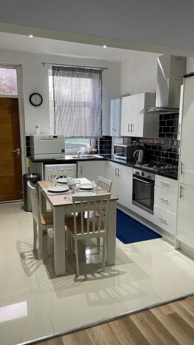 a kitchen with a table and chairs in it at Potters Lodge, Oldham, Manchester by Edl Ventures Ltd in Oldham