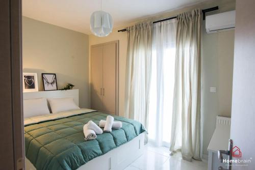 1 dormitorio con 1 cama con 2 toallas en MOS luxury project by Homebrain, en Alexandroupoli