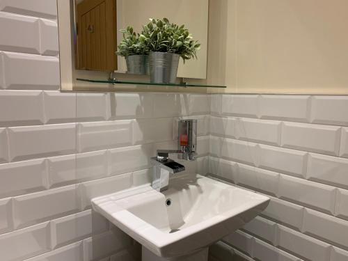 a bathroom with a white sink and a mirror at Market Place Serviced Apartments, Leek in Leek