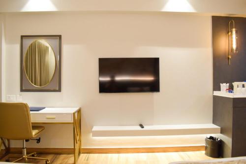 a room with a desk and a television on a wall at Tulip Inn Shravasti in Katra