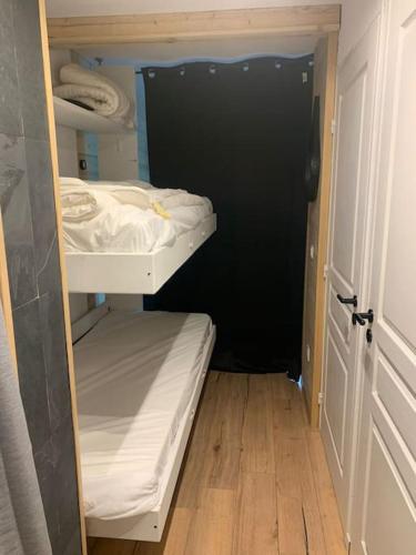ein kleines Zimmer mit 2 Etagenbetten und einer schwarzen Tür in der Unterkunft Studio Le flocon in Vars