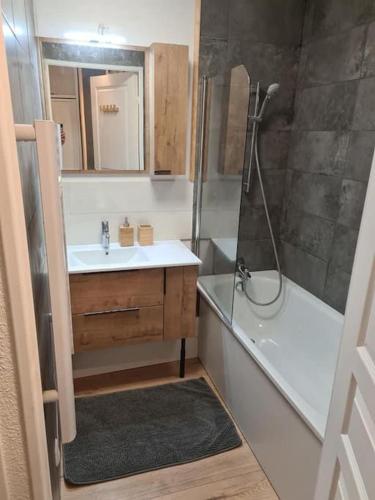 ein Badezimmer mit einer Dusche, einem Waschbecken und einer Badewanne in der Unterkunft Studio Le flocon in Vars
