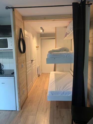 ein kleines Zimmer mit 3 Etagenbetten und einer Küche in der Unterkunft Studio Le flocon in Vars