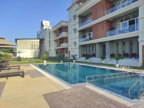 a swimming pool in front of a building at Palm Resorts in Tinsukia