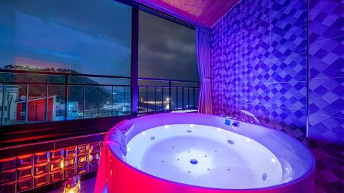 a bath tub in a room with a window at Geoje Highend Spa Pension in Geoje 