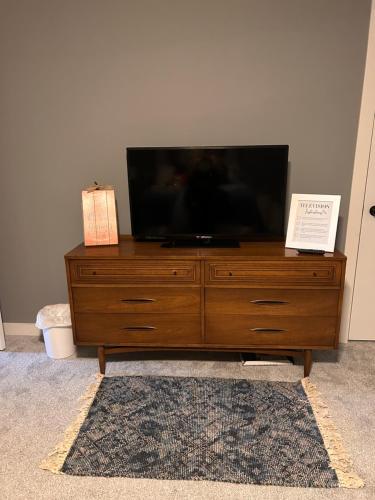 a flat screen tv sitting on top of a wooden dresser at McLaughlin home in Osceola