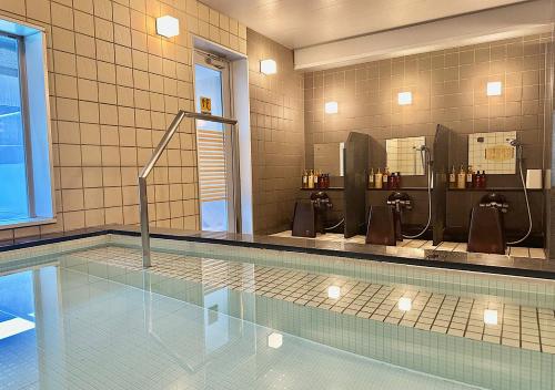 a swimming pool with two urinals and a swimming pool Wythonythonythonython at APA Hotel TKP Sapporo Eki-Kitaguchi Excellent in Sapporo