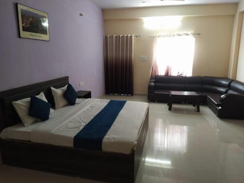ein Schlafzimmer mit einem großen Bett und einem Sofa und einem Sofa in der Unterkunft Hotel Ghirdharval Near Maa Trikuta Temple-Kunhadi-Kota in Kota