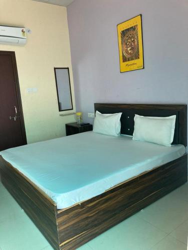 ein Schlafzimmer mit einem großen Bett mit blauer Bettwäsche in der Unterkunft Hotel Ghirdharval Near Maa Trikuta Temple-Kunhadi-Kota in Kota