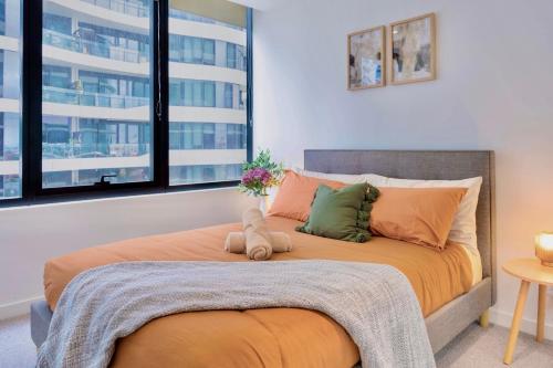 - une chambre dotée d'un grand lit avec des draps et des oreillers orange dans l'établissement Minutes from Melbourne CBD - FREE Parking, à Footscray