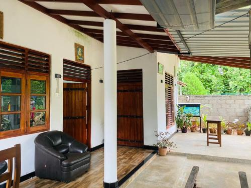 Una sala de estar con una silla de cuero negro en una casa. en Grand Freedom Udawalawe, en Udawalawe