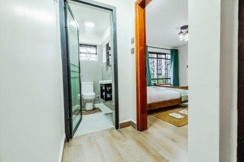 a bathroom with a glass door leading to a bedroom at Sky Oasis Home in Nairobi