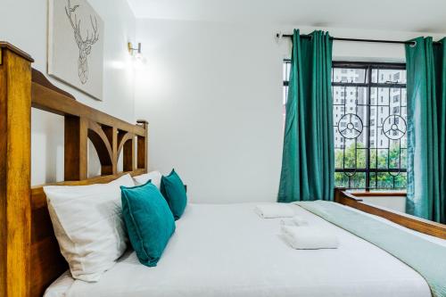 a bedroom with a bed with green curtains and a window at Sky Oasis Home in Nairobi
