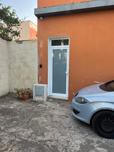 une voiture garée devant une maison avec une porte bleue dans l'établissement APARTENERIFE, à La Laguna