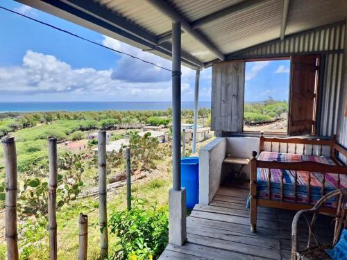 a porch with a bed and a view of the ocean at L'Arche in Rodrigues Island