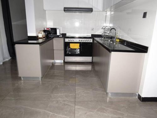 a kitchen with a black and white stove top oven at Three Bedroom Luxury Apartment in Nairobi