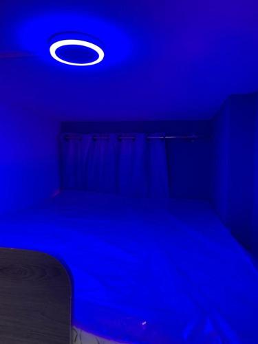 a blue room with a bed and a blue light at Ocean View in Dubai