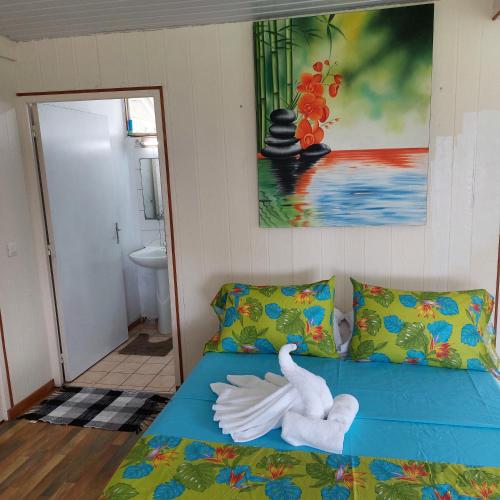 Una habitación con una cama con cisnes. en Maruhana lodge, en Teahupoo
