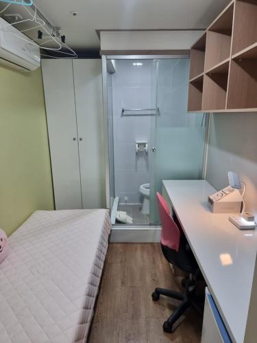 a room with a bed and a desk and a shower at Gangnam Best Dormitory in Seoul