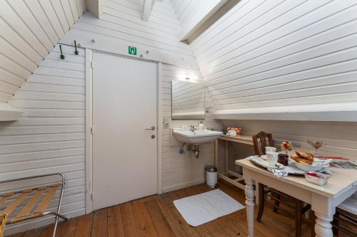 baño con lavabo y puerta blanca en Het Geerwijn - gastensuite in hartje Brugge en Bruges