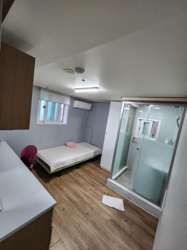 a small room with a bed and a mirror at Gangnam Best Dormitory in Seoul