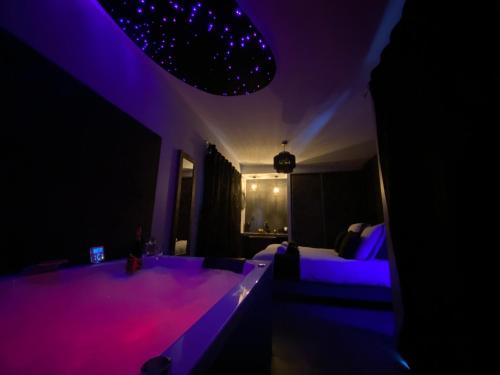 uma sala de estar com luzes roxas num quarto em L'Eden em Saint-Rémy-lès-Chevreuse