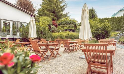 a group of tables and chairs with umbrellas at ADLER HÄUSERN Gourmet & Spa Hotel in Häusern