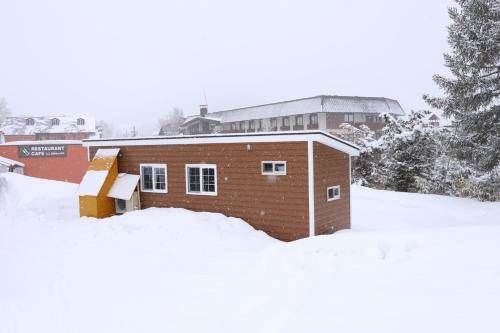 un pequeño edificio de ladrillo en la nieve en Hotel Japan Shiga en Yamanouchi