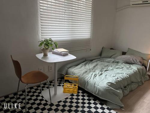 um quarto com uma cama, uma mesa e uma cadeira em Tolerance em Incheon