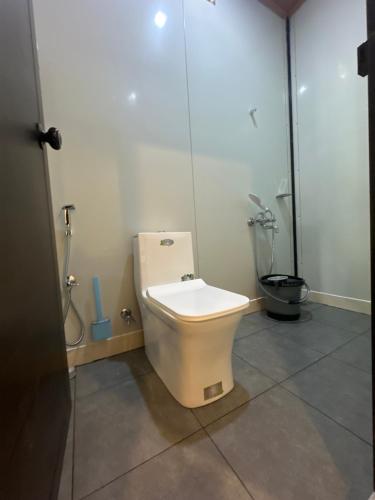 a bathroom with a toilet and a shower stall at WHOOSH HOMES in Cochin