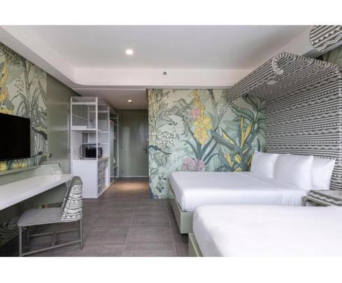 ein Hotelzimmer mit 2 Betten und einem TV in der Unterkunft Astoria Palawan in San Jose