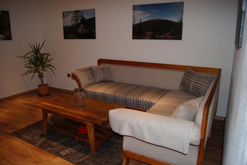 uma sala de estar com um sofá e uma mesa de centro em Ferienwohnung Bayerwaldblick em Jandelsbrunn