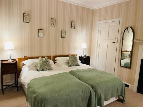a bedroom with a large bed with two pillows at Newholme House in Stirling