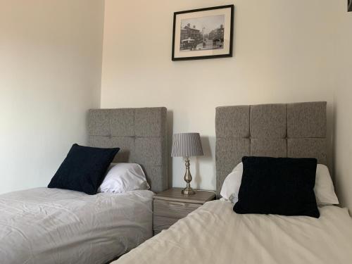 two beds sitting next to each other in a bedroom at Market Place Serviced Apartments, Leek in Leek