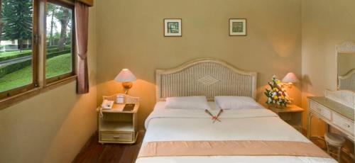 ein Schlafzimmer mit einem Bett mit einer Uhr drauf in der Unterkunft pangrango resort 