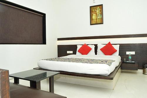 a bedroom with a bed with red pillows at HOTEL SUNIL INN in Raipur