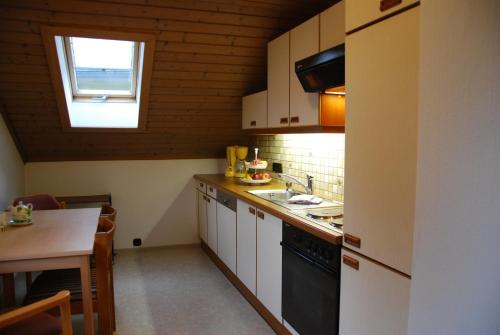 Elle comprend une petite cuisine avec un évier et une fenêtre. dans l'établissement Apartmenthaus Maxl, à Bad Hofgastein