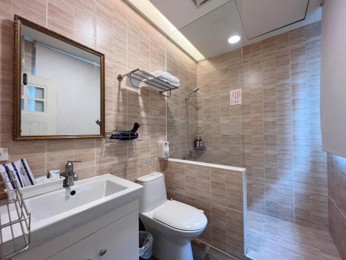 een badkamer met een toilet, een wastafel en een spiegel bij Love The Countryside B&B in Hualien