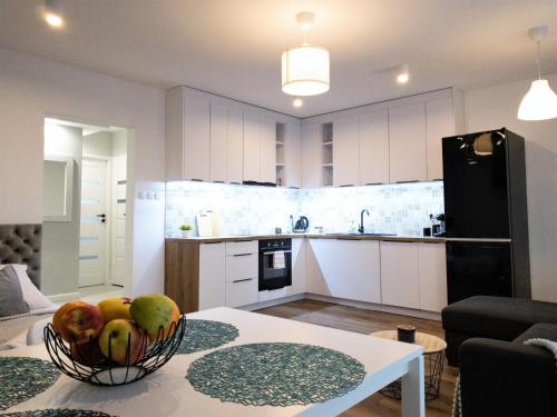 a kitchen with a bowl of fruit on a table at Apartament Skandynawski in Mielec