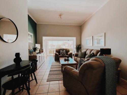 a living room with a couch and a table at X7 -Goose Valley-Ocean Views in Plettenberg Bay