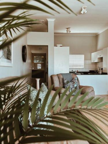 a living room with a couch and a kitchen at X7 -Goose Valley-Ocean Views in Plettenberg Bay