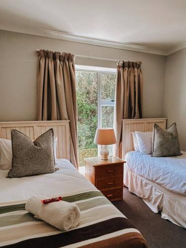 a bedroom with two beds and a window at X7 -Goose Valley-Ocean Views in Plettenberg Bay