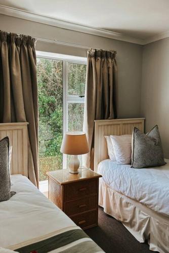 sypialnia z 2 łóżkami i oknem w obiekcie X7 -Goose Valley-Ocean Views w mieście Plettenberg Bay