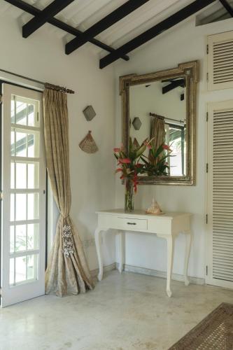 a room with a table and a mirror and a window at Coco Tangalla in Tangalle